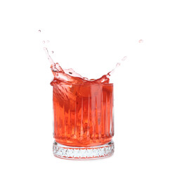 Glass of classic negroni cocktail with splashes on white background