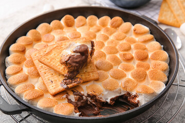 Frying pan with tasty S'mores dip on table, closeup - obrazy, fototapety, plakaty