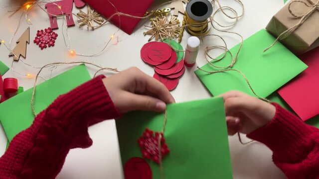 Girl making an advent calendar from green paper, do-it-yourself advent calendar, children's creativity, top view,DIY