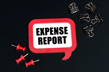 On a black surface, office supplies and a red plaque with the inscription - Expense report
