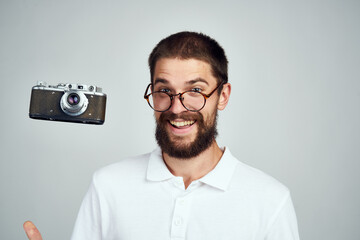 Cheerful man with a camera in his hands. Professional fashion lifestyle.