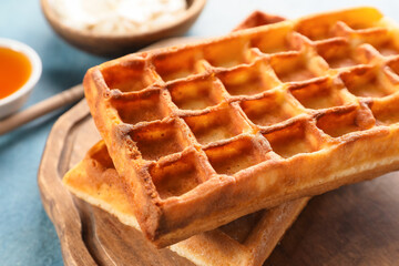 Board with yummy Belgian waffles on table, closeup