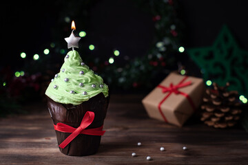 Christmas tree-shaped cupcake with a star candle and gifts.