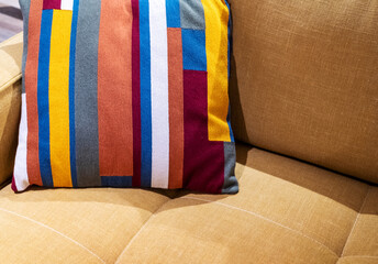 Multicolored pillow on yellow sofa background