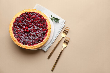 Plate with tasty lingonberry pie on color background