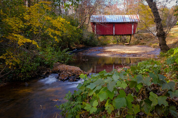 Campbell's covered bridge in Greer, South Carolina, USA with fall foliage and smooth water in stream - obrazy, fototapety, plakaty