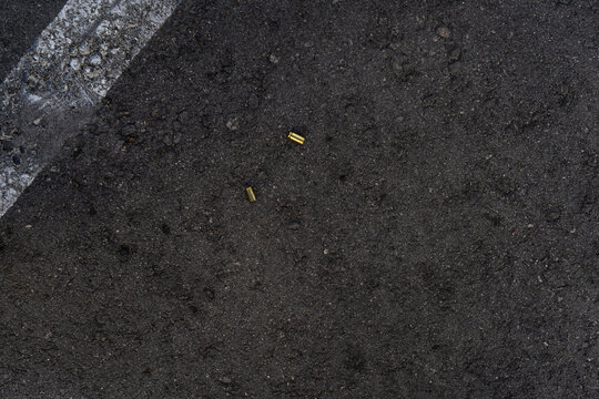 Two different caliber bullet shell casings on asphalt street