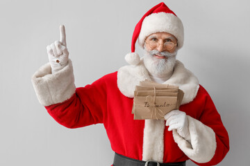 Santa Claus with letters showing something on grey background