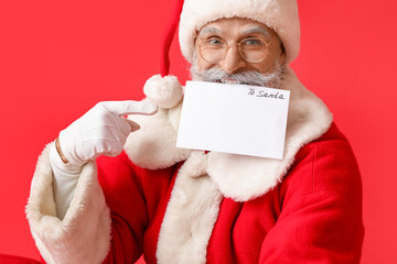 Santa Claus with letter on red background