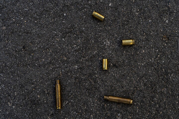 Two different caliber bullet shell casings on asphalt street