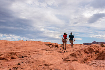 Fototapeta premium Two hikers searching for the famous Fire Wave in Valley of Fire, Nevada