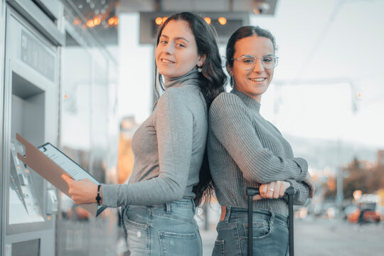 Mujeres de negocios sonrientes trabajando en equipo en la estaci&oacute;n de tren con equipaje y maletas para viajar de ruta hasta su empresa