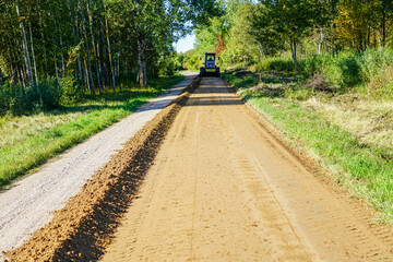 gravel road leveling in rural areas with the help of a grader