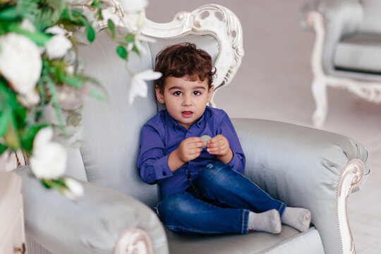 little boy sitting on a light chair