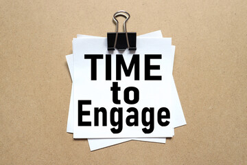 TIME TO ENGAGE. text on white sticker on wood background