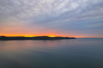 Fototapeta na wymiar One hundred percent cloud covered sunrise over the sea