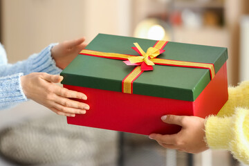 Women with beautiful Christmas gift box at home, closeup
