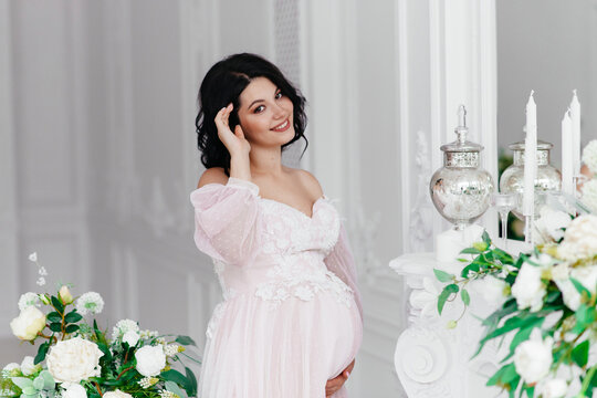 Beautiful pregnant girl in a dress in a bright room