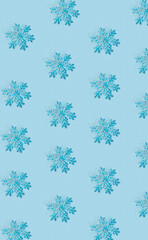 Winter Christmas pattern with snowflakes on pastel blue background. Minimal Xmas eve or Happy New Year celebration concept. Elegant winter holidays greeting card. Flat lay, top view.