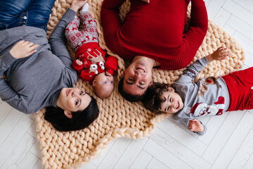 A happy family with children lies on the floor