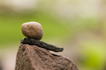 Fototapeta na wymiar Small stack of little brown, grey rocks and stones in balance and harmony with the environment creating a calm and relaxing image of mindfulness