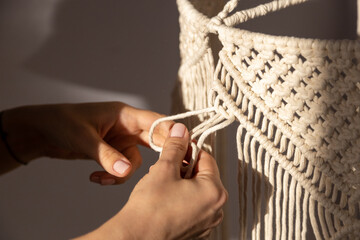 closeup weaving of macrame threads , women's hands