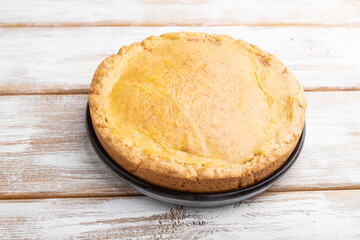 Autumn onion pie and cup of coffee on white wooden background. Side view.