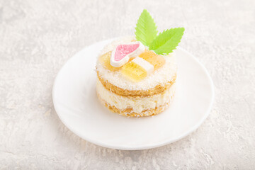 Decorated cake with milk and coconut cream on a gray concrete background. Side view.