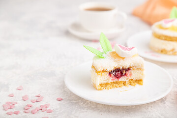 Decorated cake with milk and coconut cream with cup of coffee on a gray concrete background. Side view, copy space.