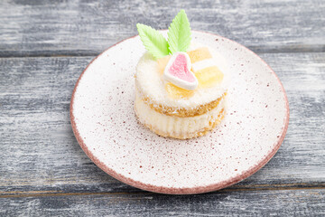Decorated cake with milk and coconut cream on a gray wooden background. Side view.