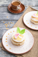 Decorated cake with milk and coconut cream with cup of coffee on a gray wooden background. Side view.