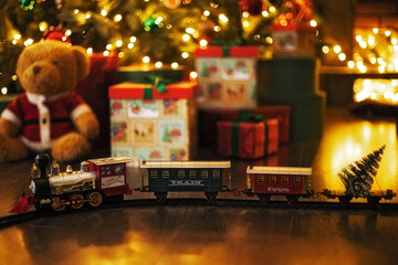 christmas locomotive on railway while stands on christmas interior background, christmas concept
