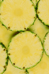 Pineapple juicy yellow slices background. Top view.