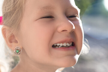 Naklejka premium Portrait of a little girl with an outstretched milk tooth