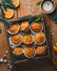 Pumpkin Cupcakes with orange glase on wooden backdrop with winter decoration