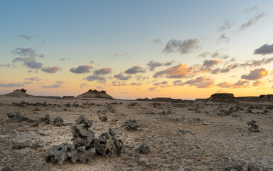 Desert Landscape. A raw portrayal of Southern Oman's desert terrain, with scattered rocks and a dramatic sky at twilight.