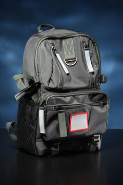 Large backpack on a dark background. Black backpack with a lot of kormans. Concept - sale of bags and backpacks. Carrying bag on the back. City bag for carrying on back. Modern Urban Bag