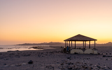 Serene Beachfront Gazebo at Sunset. A peaceful moment captured during sunset with a gazebo...