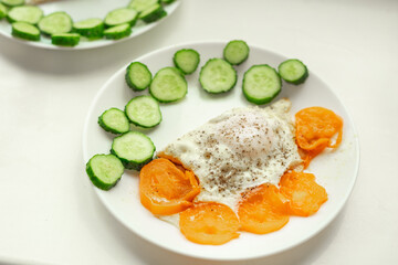 Soft focus, breakfast plate. Selective focus. Sliced cucumber, fried scrambled eggs close up.	