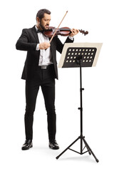 Male violinist playing a violin in front of a sheet music stand