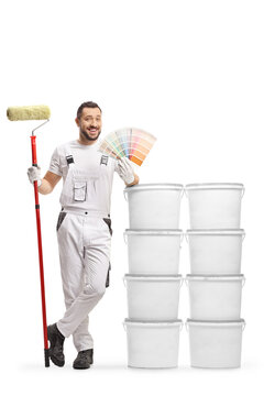 Full length portrait of a house painter leaning on buckets and holding a color palette