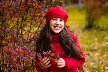 Beautiful girl in sunny autumn park. Child playing in park at autumn. Autumn mood.
