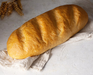 Picture of loaf of rye homemade white bread isolated on white towel spread on white table