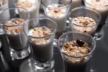 Creamy dessert of nuts in a glass stack on a dark background.