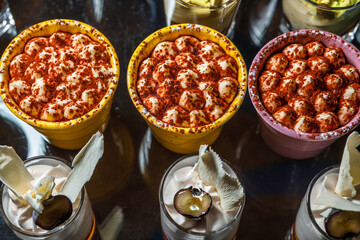 Dessert of whipped cream sprinkled with seasoning in cups.