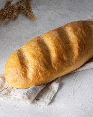 Freshly baked white bread with crispy crust on linen kitchen towel isolated on white background