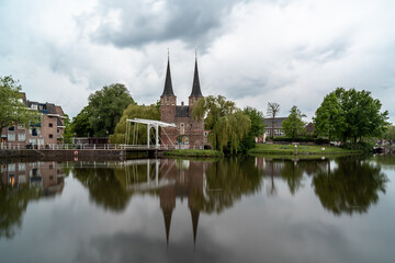Fototapeta na wymiar Delft Oostpoort, a historic gateway with a scenic reflection and cloudy sky