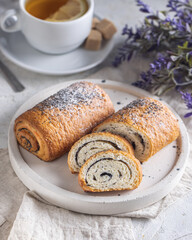 Homemade sweet poppy seed rolls or strudels with some slices sprinkled with poppy seeds