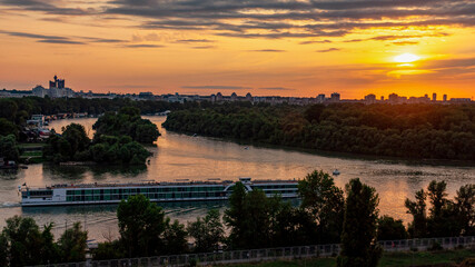 Fototapeta premium Sunset over the city with river and boat serbia belgrade