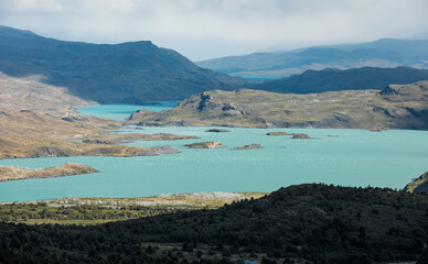 Obraz premium Plain hills and turquoise lake water of Torres del Paine National Park, Chile